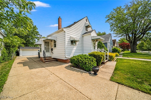 23701 Colbourne Rd, Euclid, OH 44123 - view of front of property featuring an outdoor structure, a chimney, a front yard, entry steps, and a detached garage