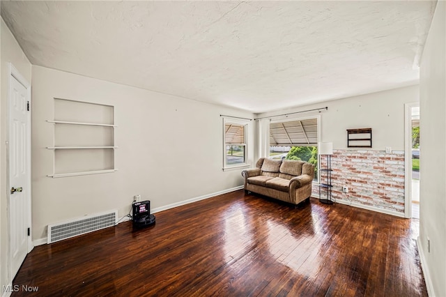 23701 Colbourne Rd, Euclid, OH 44123 - sitting room with plenty of natural light, hardwood / wood-style flooring, built in shelves, baseboards, and a textured ceiling