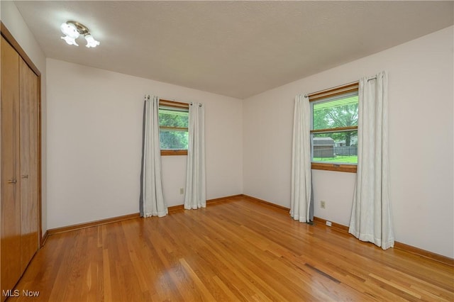 1214 Highwood Dr, New Franklin, OH 44216 - unfurnished bedroom with multiple windows, light wood-type flooring, baseboards, and a closet