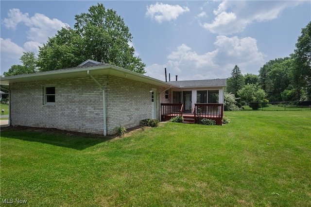 1214 Highwood Dr, New Franklin, OH 44216 - back of house with a deck, a yard, a sunroom, and brick siding