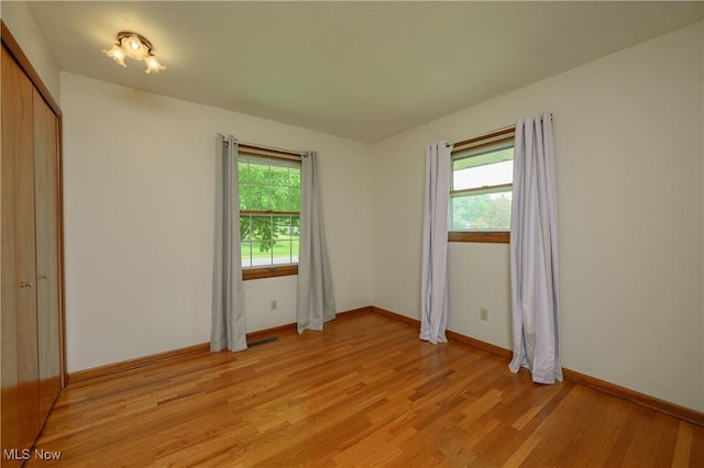 1214 Highwood Dr, New Franklin, OH 44216 - unfurnished bedroom with multiple windows, light wood-type flooring, and baseboards