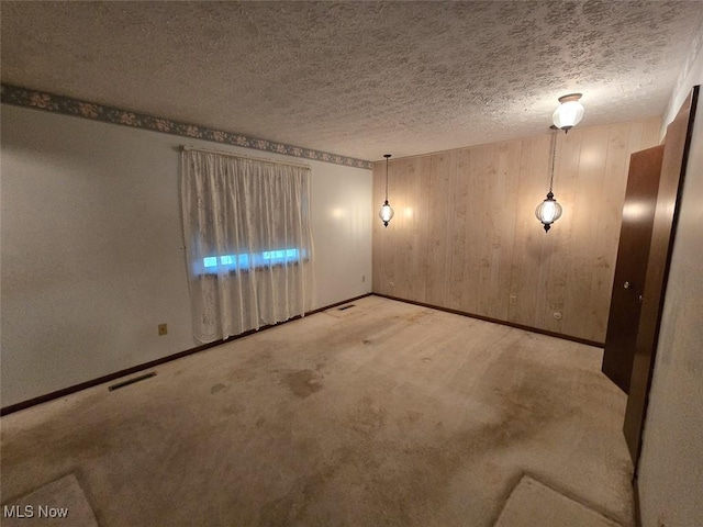 3212 Foxmoor St NE, Hartville, OH 44632 - carpeted spare room with baseboards, wooden walls, and a textured ceiling
