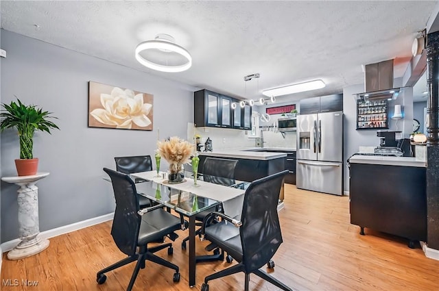 245 N Rd, Niles, OH 44446 - dining space featuring light wood-style flooring, a textured ceiling, and baseboards