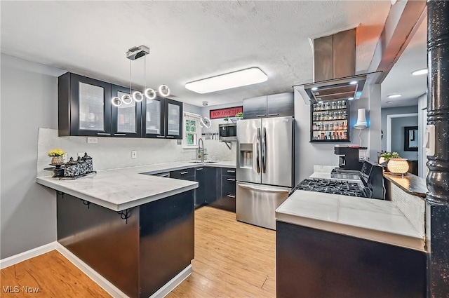245 N Rd, Niles, OH 44446 - kitchen with appliances with stainless steel finishes, a peninsula, glass insert cabinets, a sink, and light wood-type flooring