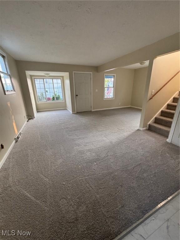4721 Ardmore Ave, Cleveland, OH 44144 - unfurnished living room featuring baseboards, stairs, and carpet floors