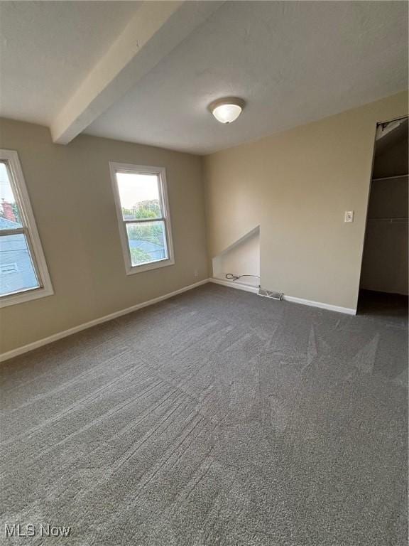 4721 Ardmore Ave, Cleveland, OH 44144 - spare room featuring baseboards, beamed ceiling, and dark colored carpet