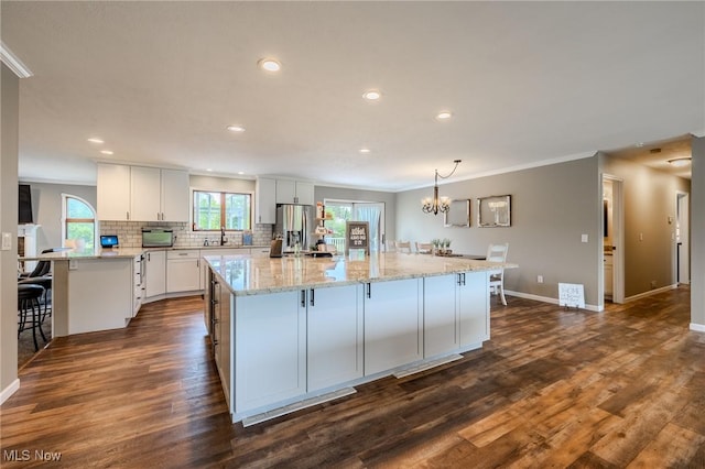 8921 Auburn Rd, Chardon, OH 44024 - kitchen featuring recessed lighting, white cabinets, decorative backsplash, a breakfast bar, and ornamental molding