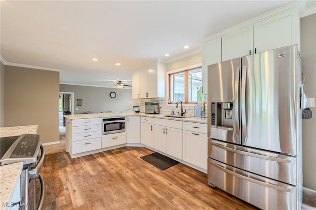 8921 Auburn Rd, Chardon, OH 44024 - kitchen with stainless steel appliances, a sink, ornamental molding, healthy amount of natural light, and a peninsula