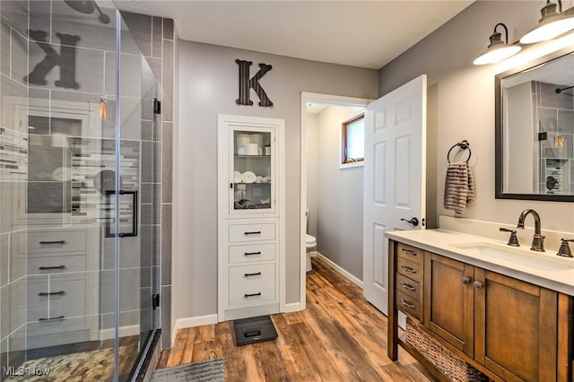 8921 Auburn Rd, Chardon, OH 44024 - bathroom featuring vanity, a shower stall, wood finished floors, toilet, and baseboards