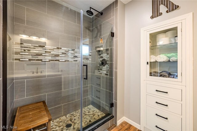 8921 Auburn Rd, Chardon, OH 44024 - bathroom with a shower stall, wood finished floors, and baseboards