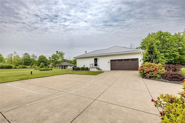 8921 Auburn Rd, Chardon, OH 44024 - view of front facade with a front yard, driveway, an attached garage, and metal roof