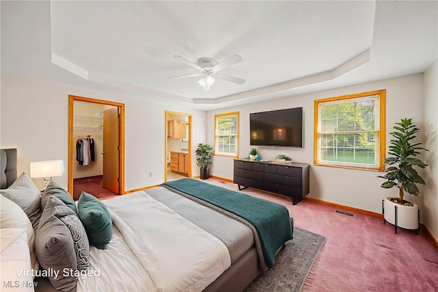7410 Fieldstone Ave, Conneaut, OH 44030 - carpeted bedroom with a raised ceiling, baseboards, a walk in closet, connected bathroom, and ceiling fan