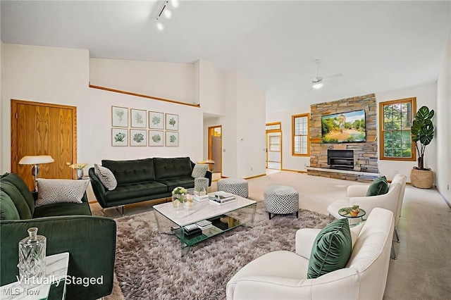 7410 Fieldstone Ave, Conneaut, OH 44030 - carpeted living area with ceiling fan, track lighting, a fireplace, high vaulted ceiling, and baseboards