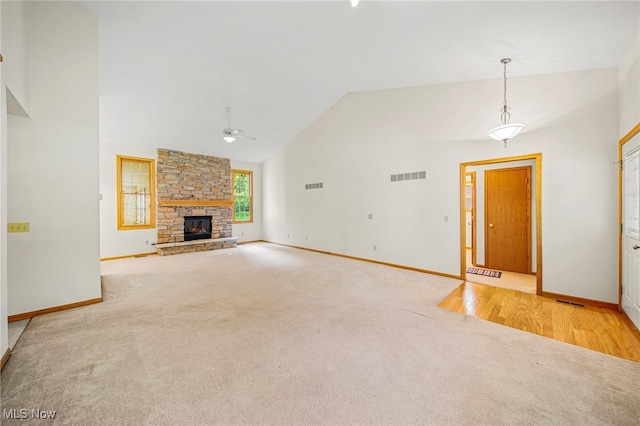 7410 Fieldstone Ave, Conneaut, OH 44030 - unfurnished living room featuring carpet, a ceiling fan, baseboards, a stone fireplace, and high vaulted ceiling