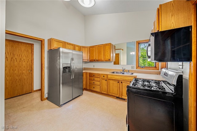 7410 Fieldstone Ave, Conneaut, OH 44030 - kitchen featuring stainless steel fridge with ice dispenser, range with gas cooktop, a sink, a high ceiling, and light countertops