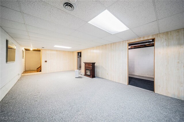 7410 Fieldstone Ave, Conneaut, OH 44030 - finished basement featuring a drop ceiling, carpet flooring, a fireplace, and wood walls
