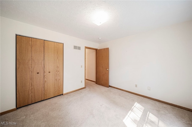 7410 Fieldstone Ave, Conneaut, OH 44030 - unfurnished bedroom with baseboards, a closet, light colored carpet, and a textured ceiling