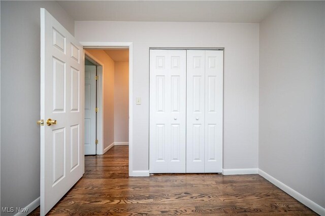 3406 Rebecca Dr, Canfield, OH 44406 - unfurnished bedroom with dark wood-style floors, baseboards, and a closet