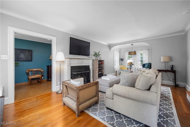 3280 Glencairn Rd, Shaker Heights, OH 44122 - living room with arched walkways, a fireplace, ornamental molding, wood finished floors, and baseboards
