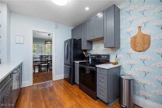 3280 Glencairn Rd, Shaker Heights, OH 44122 - kitchen with black range with electric cooktop, freestanding refrigerator, gray cabinetry, wood-type flooring, and light countertops