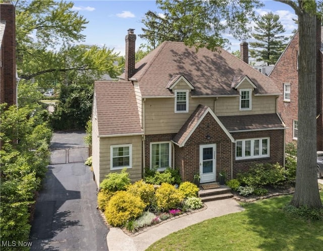 3280 Glencairn Rd, Shaker Heights, OH 44122 - view of front facade with a chimney, brick siding, a front lawn, and roof with shingles