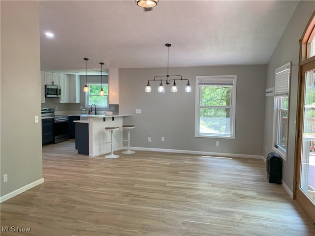 4244 Hensel Dr SW, Carrollton, OH 44615 - kitchen featuring stainless steel appliances, a breakfast bar, light countertops, a sink, and plenty of natural light