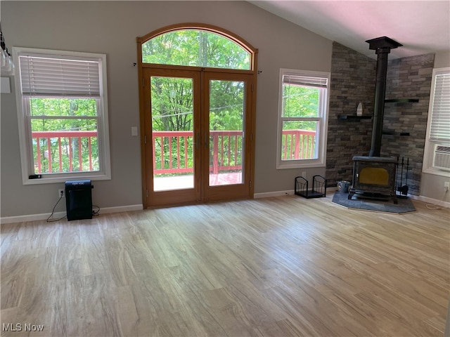 4244 Hensel Dr SW, Carrollton, OH 44615 - unfurnished living room featuring a wood stove, wood finished floors, lofted ceiling, and baseboards