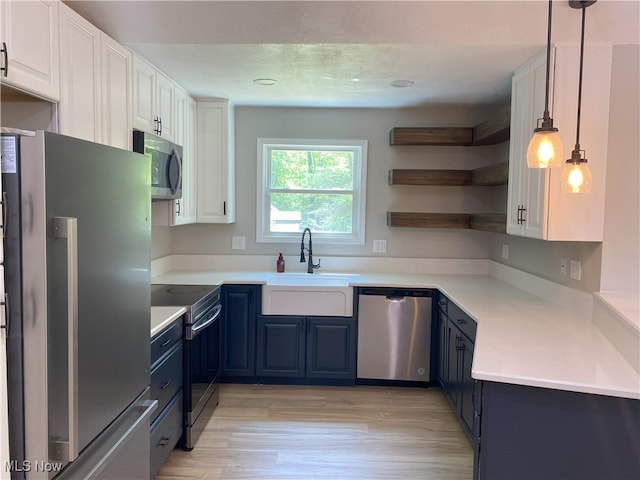4244 Hensel Dr SW, Carrollton, OH 44615 - kitchen with stainless steel appliances, blue cabinets, a sink, white cabinets, and pendant lighting