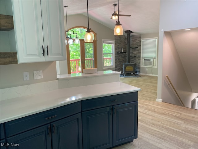 4244 Hensel Dr SW, Carrollton, OH 44615 - kitchen featuring lofted ceiling, a wood stove, blue cabinets, light wood finished floors, and light countertops