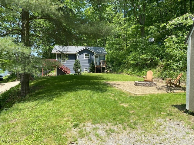 4244 Hensel Dr SW, Carrollton, OH 44615 - view of grassy yard with a fire pit, stairway, and a deck