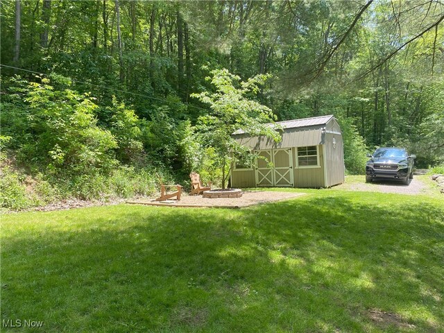 4244 Hensel Dr SW, Carrollton, OH 44615 - view of green lawn featuring a fire pit and a wooded view