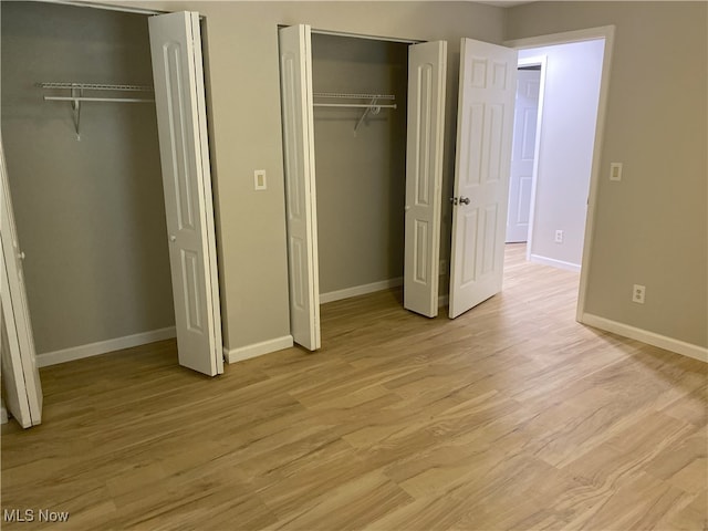 4244 Hensel Dr SW, Carrollton, OH 44615 - unfurnished bedroom with two closets, light wood-style flooring, and baseboards