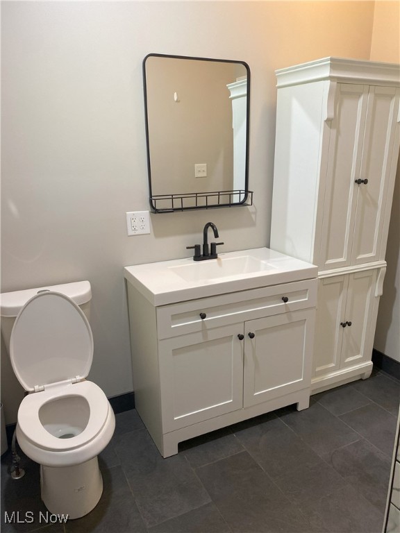 4244 Hensel Dr SW, Carrollton, OH 44615 - bathroom with vanity, toilet, baseboards, and tile patterned flooring