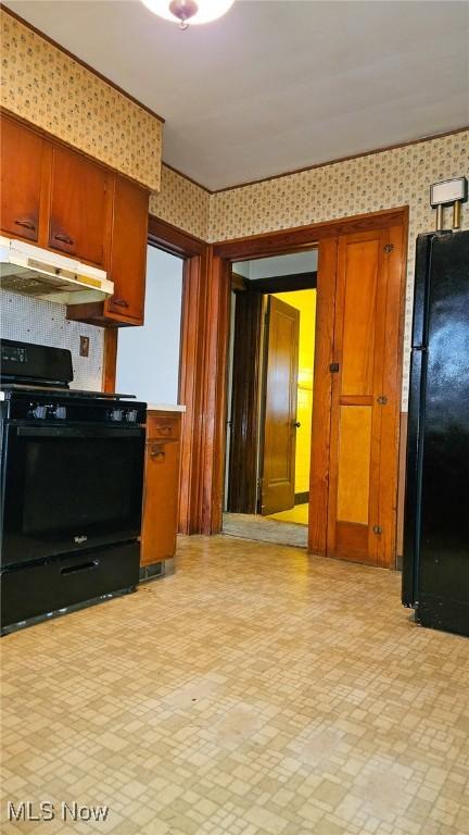 10612 Linnet Ave, Cleveland, OH 44111 - kitchen featuring black appliances, under cabinet range hood, wallpapered walls, brown cabinets, and light countertops