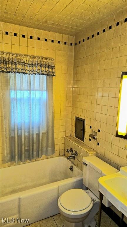 10612 Linnet Ave, Cleveland, OH 44111 - bathroom with a tub, toilet, and tile walls