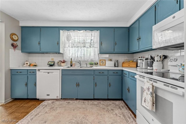 5725 Grove St, Louisville, OH 44641 - kitchen with white appliances, blue cabinets, light countertops, tasteful backsplash, and a sink