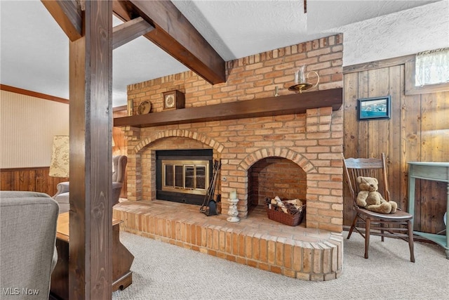 5725 Grove St, Louisville, OH 44641 - living area with wooden walls, carpet flooring, a fireplace, beam ceiling, and a textured ceiling