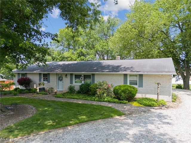 5725 Grove St, Louisville, OH 44641 - ranch-style house featuring brick siding, a front lawn, and a chimney