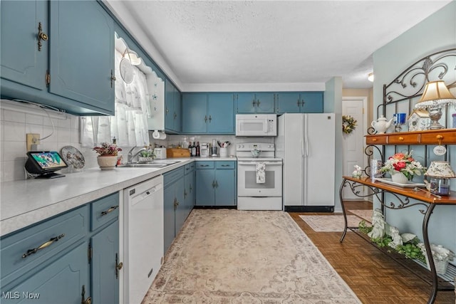 5725 Grove St, Louisville, OH 44641 - kitchen featuring white appliances, blue cabinets, a sink, light countertops, and tasteful backsplash