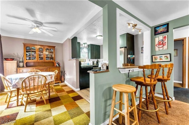 459 Lloyd Rd, Euclid, OH 44132 - kitchen with green cabinetry, dishwasher, a kitchen bar, ceiling fan, and light floors