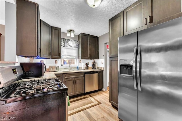 459 Lloyd Rd, Euclid, OH 44132 - kitchen with appliances with stainless steel finishes, a sink, light wood-type flooring, a textured ceiling, and light countertops