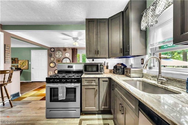 459 Lloyd Rd, Euclid, OH 44132 - kitchen featuring appliances with stainless steel finishes, a sink, light stone countertops, light wood-type flooring, and ceiling fan