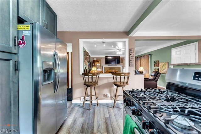 459 Lloyd Rd, Euclid, OH 44132 - kitchen featuring appliances with stainless steel finishes, light wood-style flooring, baseboards, a textured ceiling, and ceiling fan