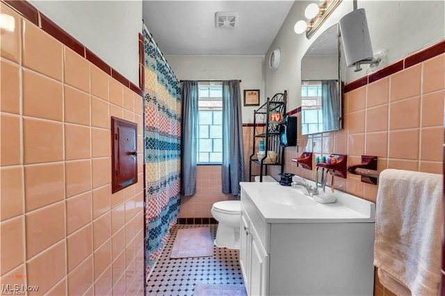 459 Lloyd Rd, Euclid, OH 44132 - bathroom featuring tile walls, toilet, vanity, wainscoting, and curtained shower