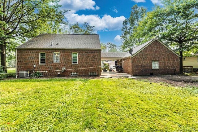 459 Lloyd Rd, Euclid, OH 44132 - rear view of house featuring a yard, brick siding, and central air condition unit