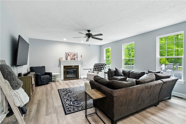 3425 Eryn Pl, Hudson, OH 44236 - living area with a ceiling fan, light wood-style flooring, a glass covered fireplace, recessed lighting, and a textured ceiling