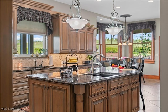 9627 State Route 152, Richmond, OH 43944 - kitchen with a sink, a kitchen island with sink, decorative backsplash, dark stone countertops, and recessed lighting