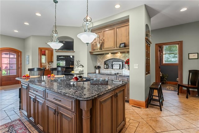 9627 State Route 152, Richmond, OH 43944 - kitchen featuring backsplash, recessed lighting, a center island, decorative light fixtures, and dark stone counters