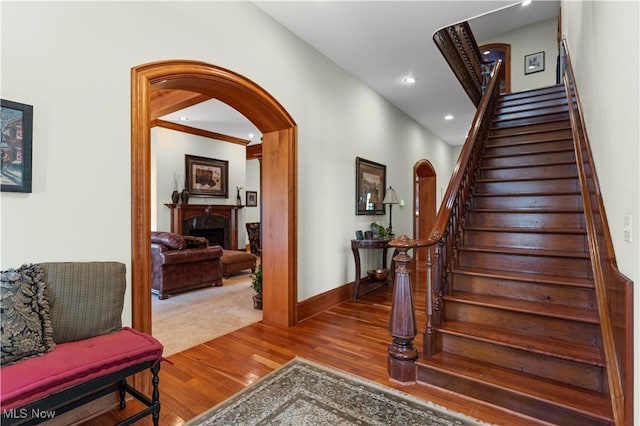9627 State Route 152, Richmond, OH 43944 - stairway featuring wood finished floors, a fireplace, baseboards, recessed lighting, and arched walkways
