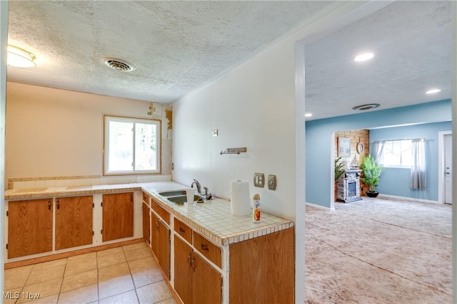 4944 Coleman Dr, Akron, OH 44319 - kitchen featuring tile countertops, a sink, a textured ceiling, light tile patterned floors, and recessed lighting